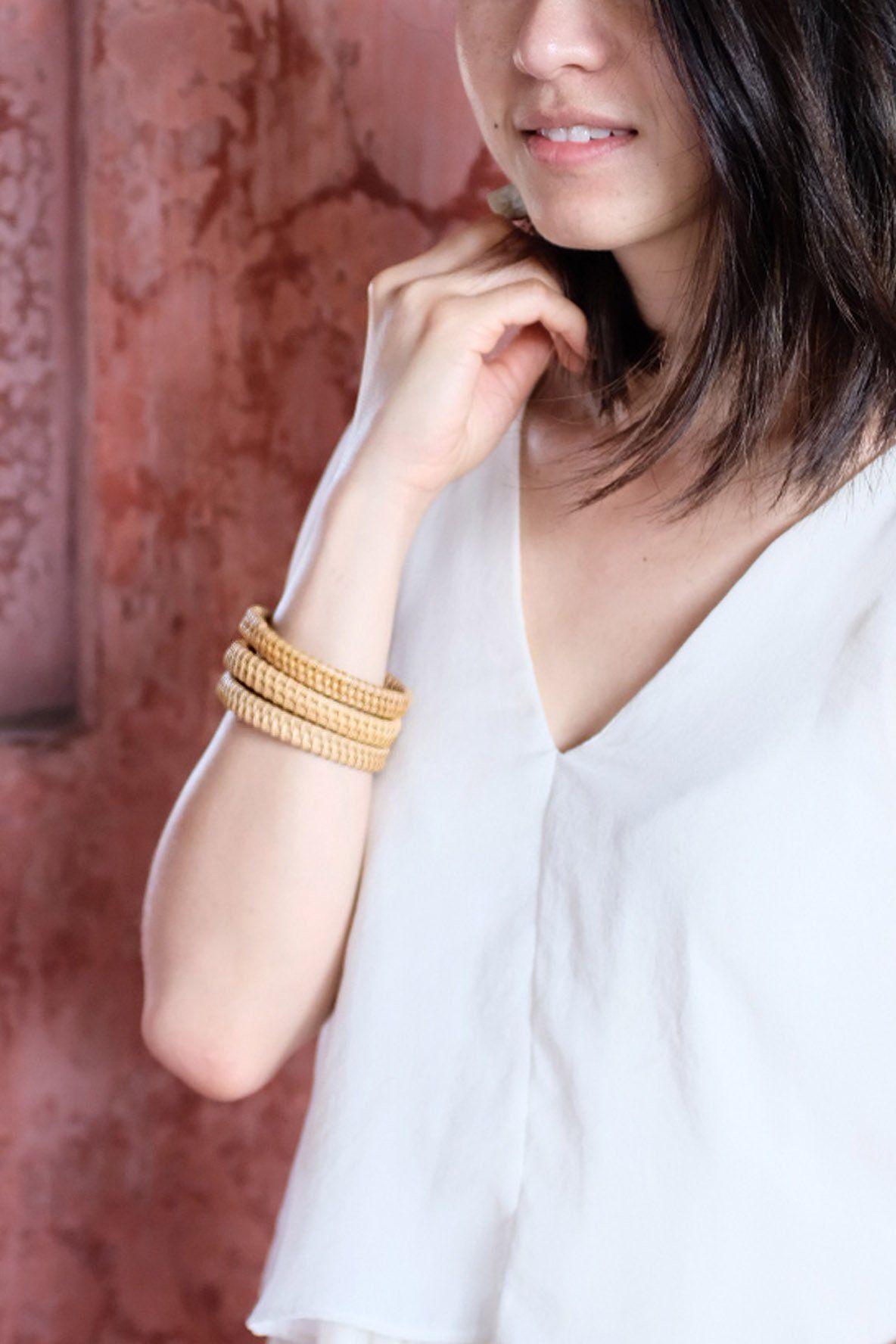 Model wearing Natural Rattan Bangle Bracelets, showcasing their handwoven design and effortless style.