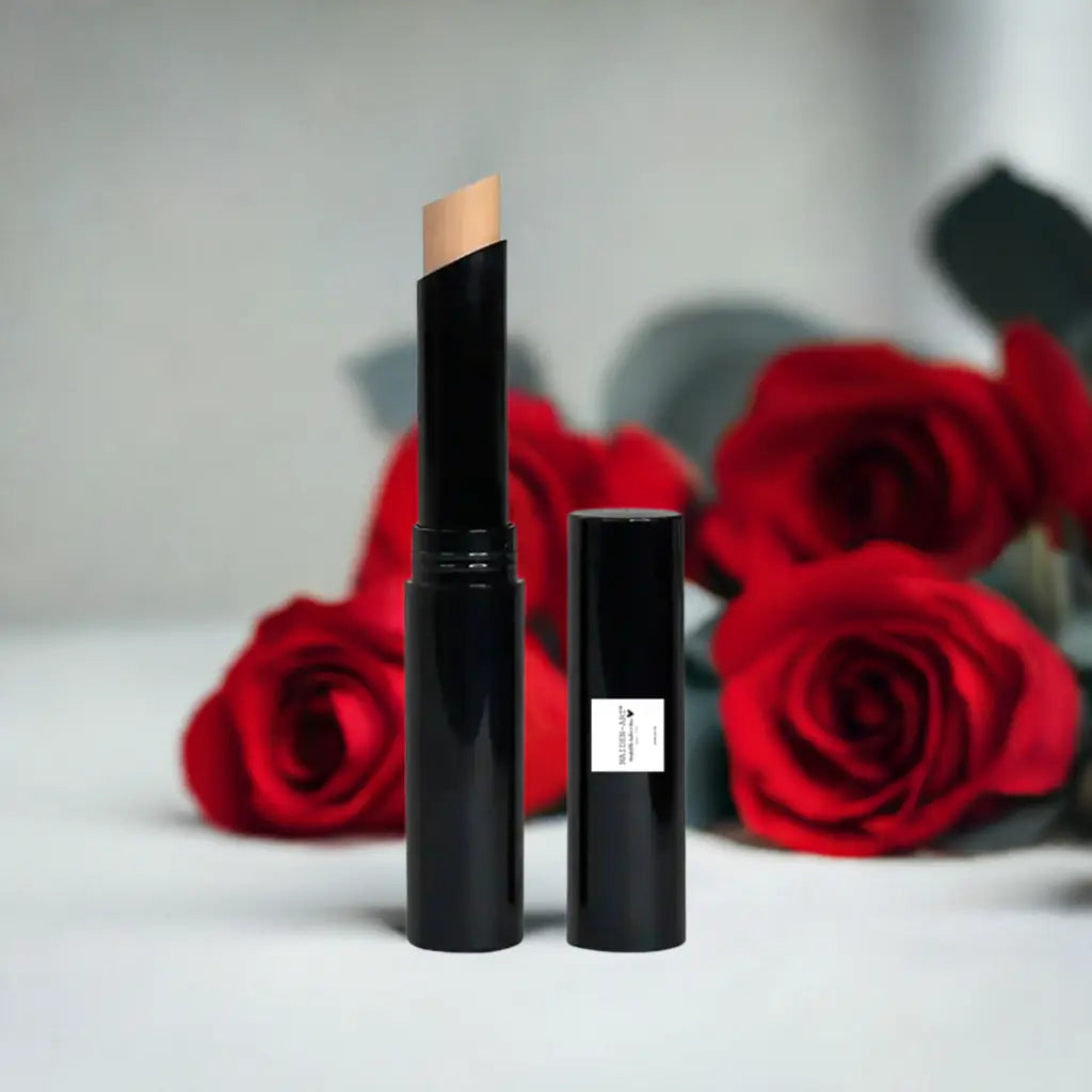 Beige concealer stick next to red roses, offering smooth makeup coverage and convenient application.