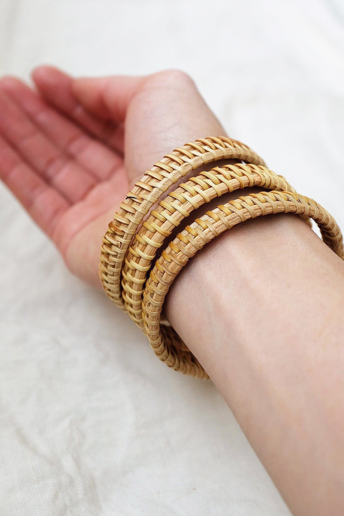 Rattan Bangle Bracelets stacked on a hand showcasing natural handwoven design and effortless style.