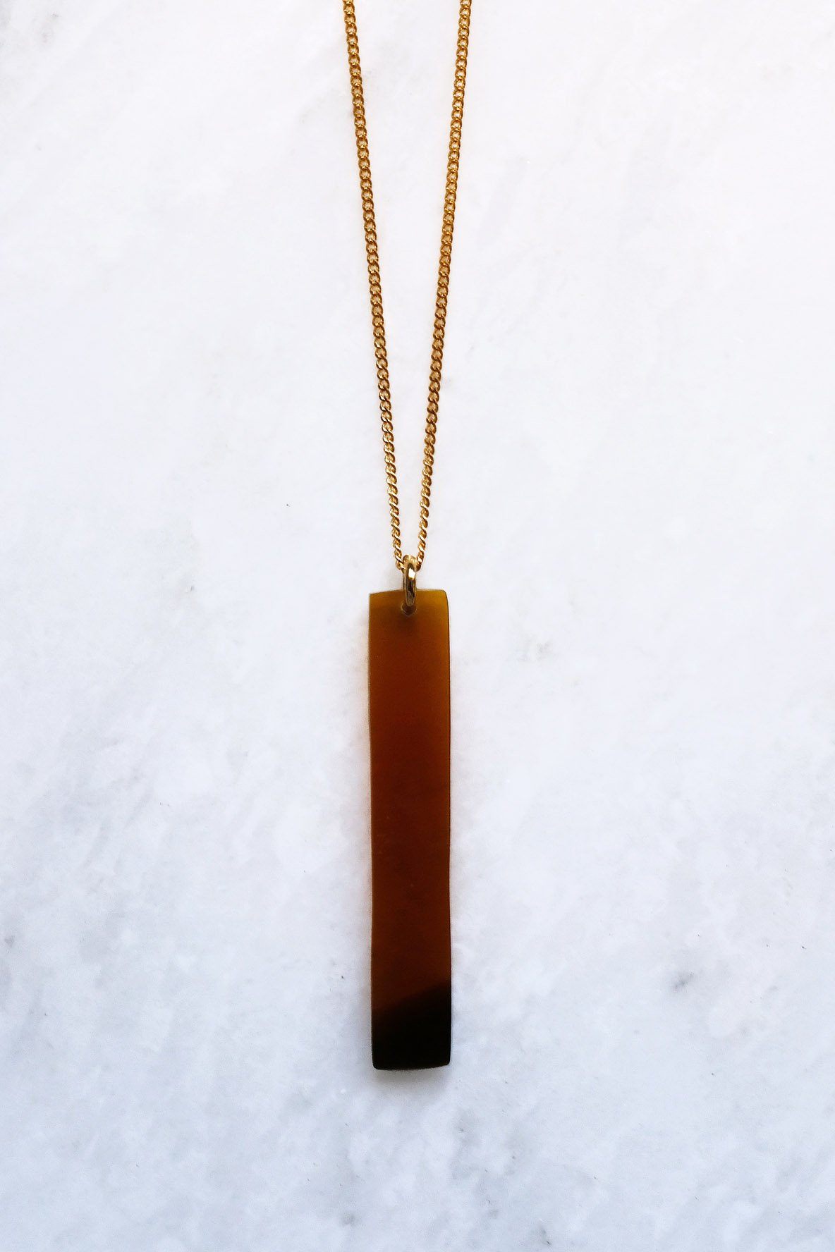 16K Gold-Plated Buffalo Horn Pendant Necklace on a gold chain with a minimalist bar design.