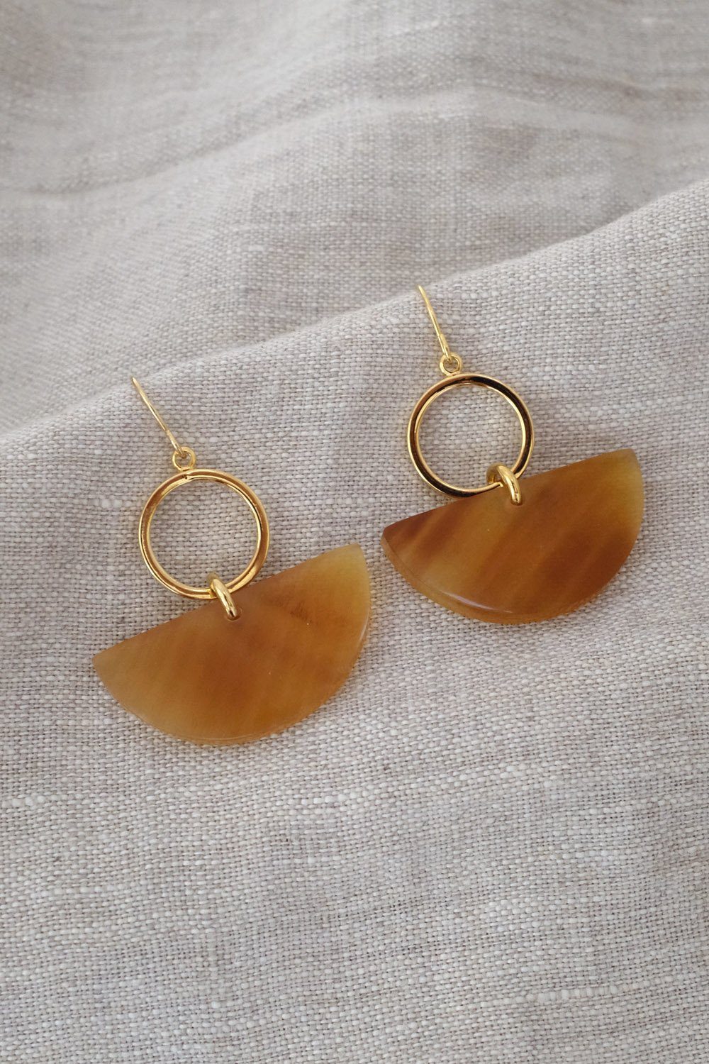 Buffalo Horn Statement Earrings | Geometric Dangle design with golden accents on a neutral fabric background.