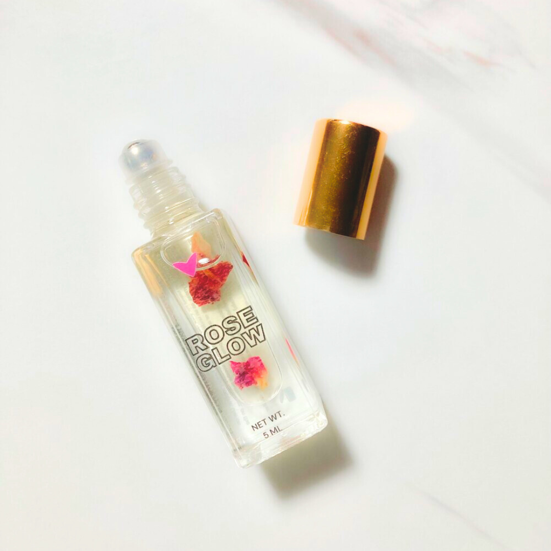Rose Glow Lip Oil in a clear bottle with floral design and gold cap, perfect for glossy shine lip care.